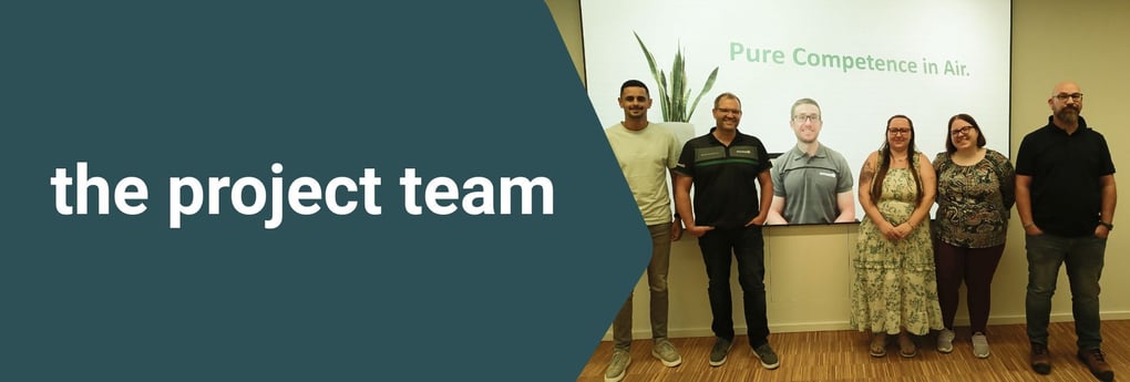 Group photo of the project team: several people stand in front of a presentation screen; on the left, the text reads “the project team”.